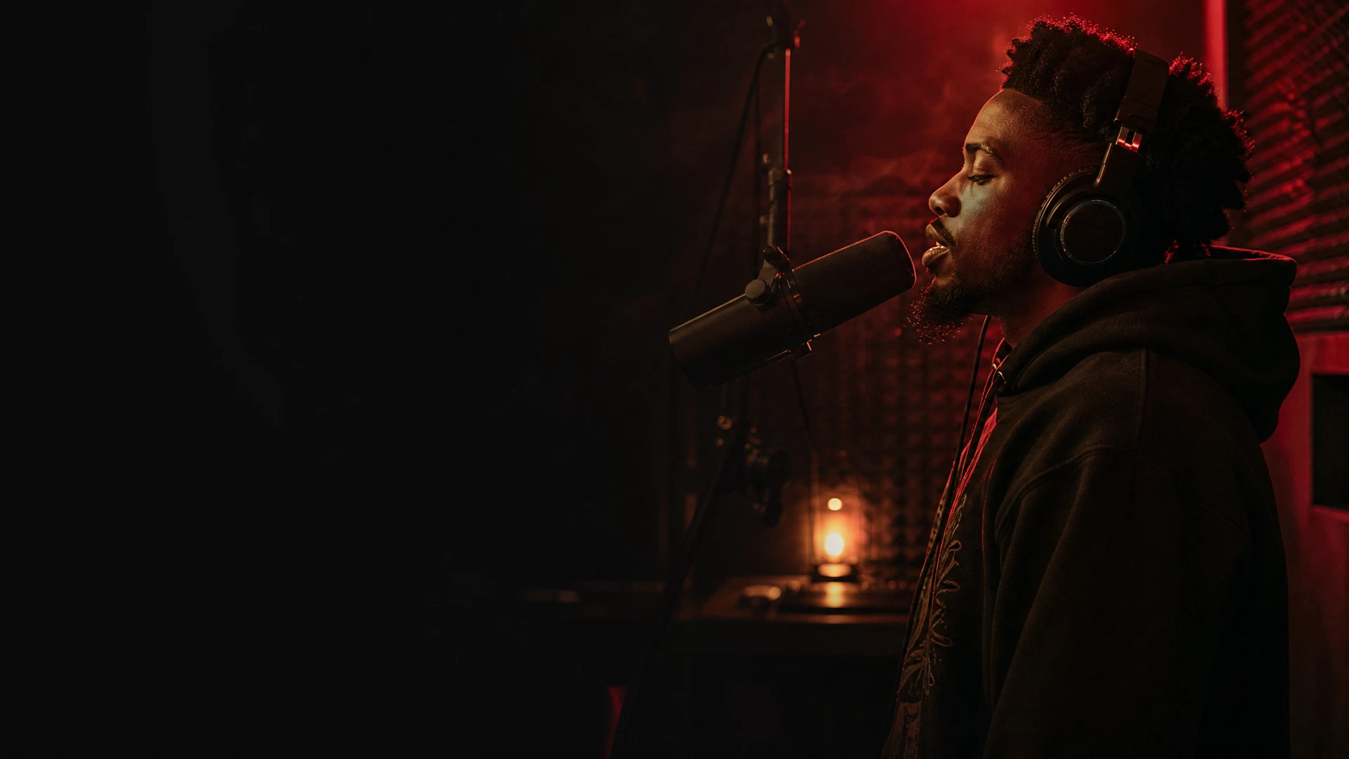 Artist recording vocals in a private red-lit studio booth
